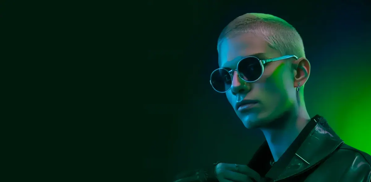 Person in sunglasses lit by green light